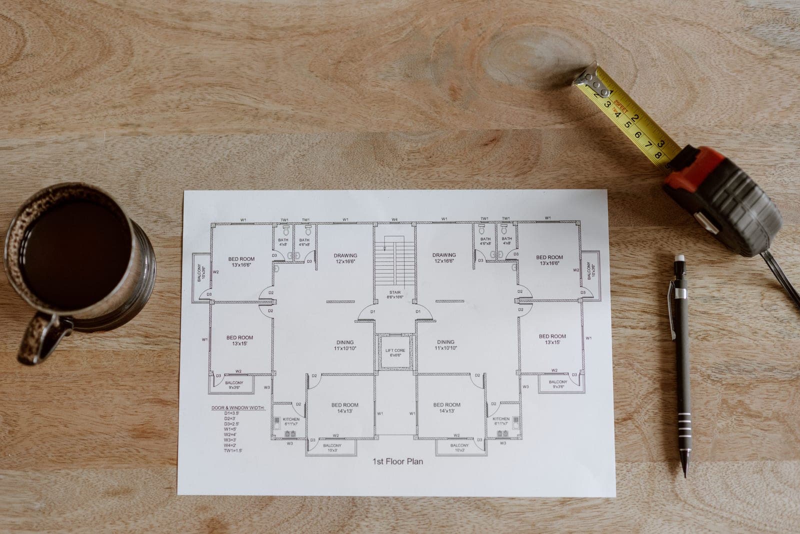 A measuring tape and floor plan laid out on a floor