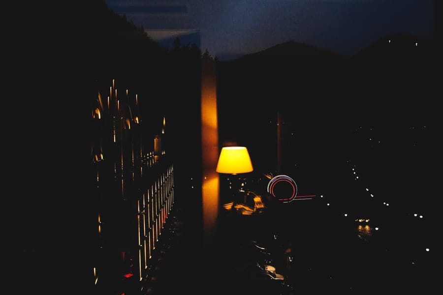 A quiet, dimly lit bedroom with a bedside lamp