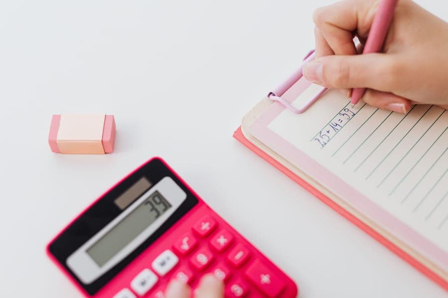 A calculator and notebook on a desk