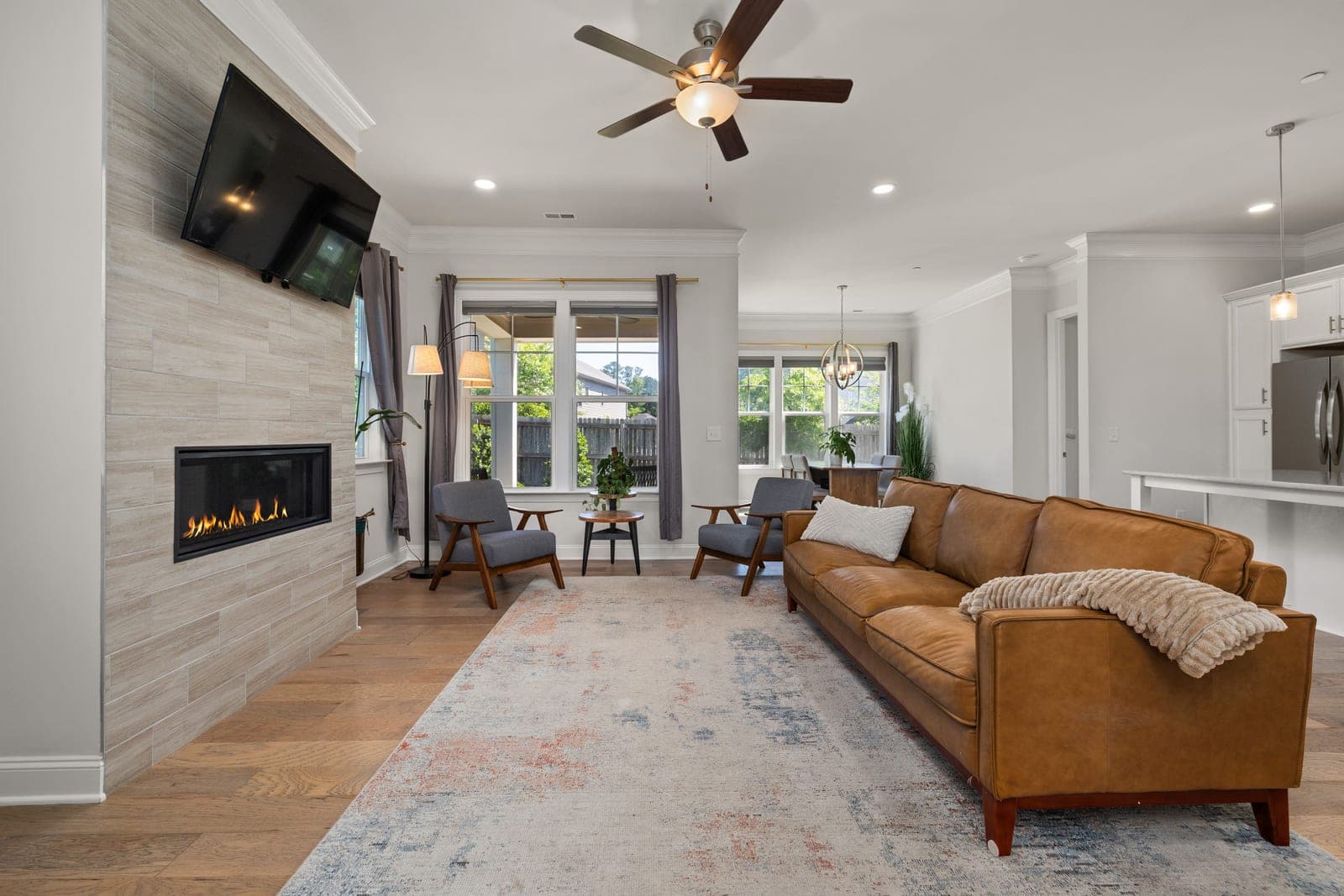 A living room with a modern sofa, a fireplace and large windows