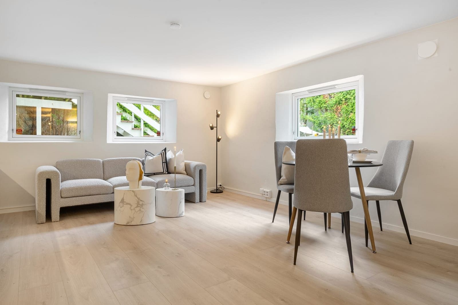 An open-plan living and dining space with a gray sofa and a dining table
